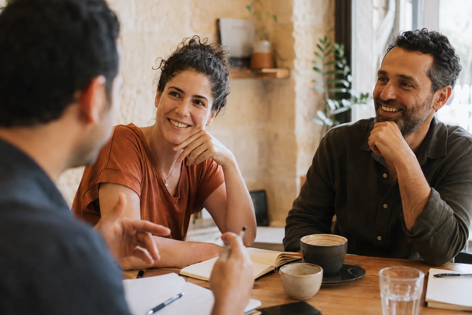 שלושה אנשים בשיחת מחקר לקוחות סביב שולחן